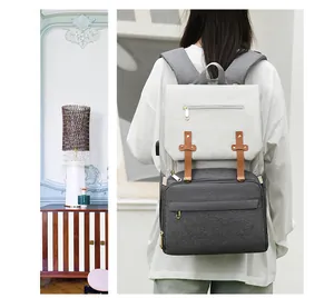 Detail of multi-functional diaper bag showing USB port and vintage leather straps