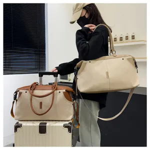 Detailed view of large canvas travel duffel with leather trim and adjustable shoulder strap
