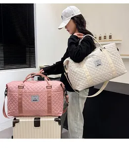Detailed view of quilted travel bags in pink and cream with adjustable shoulder straps