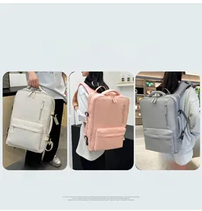 Close-up of three waterproof nylon backpacks in beige, pink, and grey with side compression buckles
