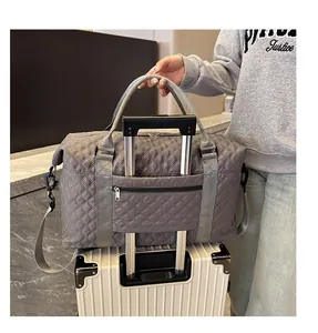 Detail of grey quilted travel bag featuring a luggage sleeve attached to a suitcase