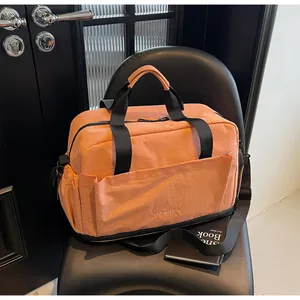 Détail du sac de sport orange avec bandoulière réglable et grande poche frontale