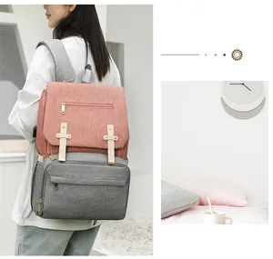 Close-up of pink and grey diaper bag with USB port and metal buckle details