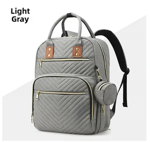 Detail view of light gray multi-functional diaper backpack with V-shape quilting and gold zippers