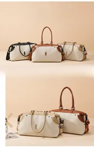 Detail view of large canvas duffle bag with leather trim and adjustable shoulder strap