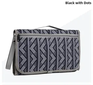 Detail of portable baby changing mat in black polka dot pattern with zipper compartment