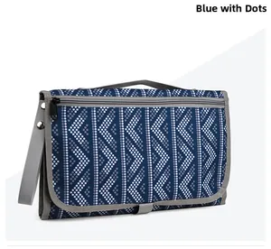 Folded blue polka dot diaper clutch with gray trim showing compact travel design