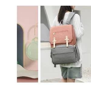 Macro detail of the pink and grey multi-functional diaper bag with gold zipper and leather straps