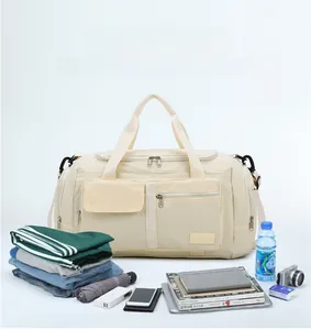 Detailed storage view of a large beige travel bag with multiple compartments and accessories