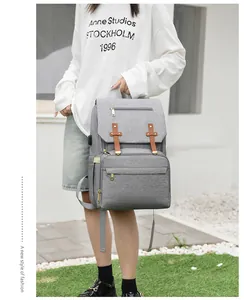 Detail view of the gray diaper bag showing side USB charging port and gold metal zippers