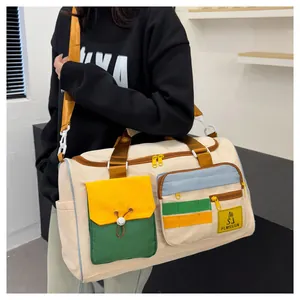 Detail of color-block travel bag featuring functional pockets and orange nylon handles