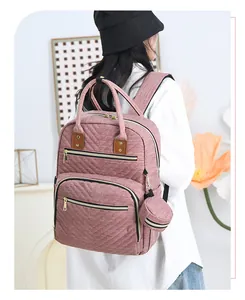 Detail view of pink quilted diaper backpack with side hanging mini round coin purse