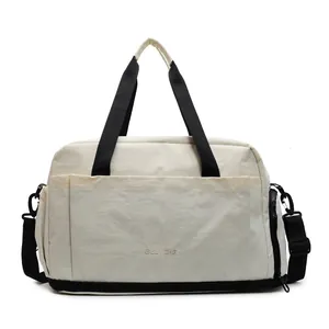 Grand sac de voyage fitness beige et noir avec compartiment chaussures et bandoulière
