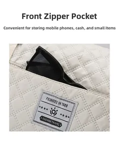 Detail of front zipper pocket on quilted travel bag featuring a fashion logo patch