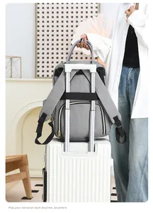 Gray diaper bag backpack with back luggage strap securely fixed to a suitcase handle