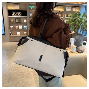 Detail of canvas travel bag with leather handles and adjustable shoulder strap