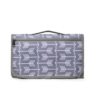 Portable waterproof baby changing mat with grey arrow pattern and folding storage handle