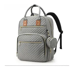 Side view of grey diaper backpack featuring V-shaped quilting and a round coin purse