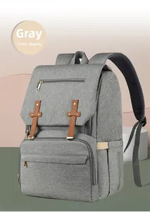 Detail of gray diaper bag showing durable canvas fabric and gold-tone zippers with USB port