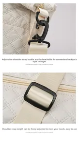Detail of adjustable nylon shoulder strap and black swivel hook on quilted travel bag