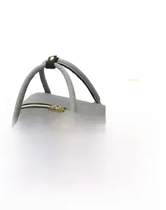 Close-up of golden dual zippers and reinforced shoulder straps on a gray diaper bag