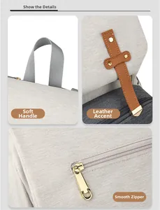 Detail view of canvas diaper bag showing soft handles, leather straps, and smooth zippers