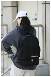 Detail view of large capacity black travel backpack featuring a separate wet and dry bottom pocket