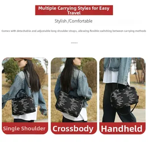 Detail of a black large-capacity travel bag showing versatile hand, shoulder, and crossbody carry