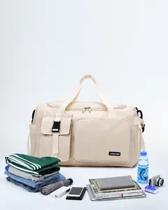 Vue détaillée du grand sac de voyage avec vêtements et accessoires sur fond blanc