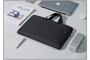 Detail of dark grey Oxford fabric laptop bag with reinforced handles in office setting
