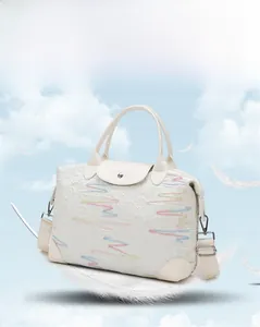 Creamy white quilted travel bag with colorful embroidery and detachable shoulder strap