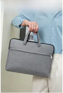 Side view of model carrying a grey waterproof Oxford fabric laptop briefcase with handles