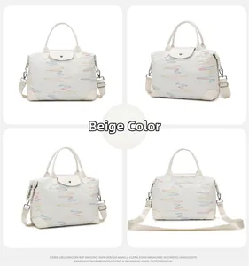 Detail of beige travel bag showing rainbow embroidery and adjustable shoulder strap