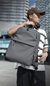 Detailed view of gray minimalist PU backpack with matte finish and long zipper pull on urban man