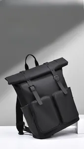 Detail of waterproof matte black backpack featuring roll-top design and twin buckle straps