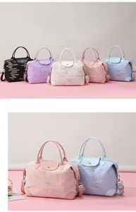 Detail view of large travel bags with wavy embroidery showing multiple colors and textures