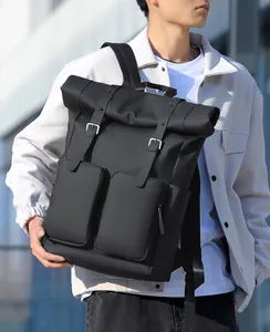 Outdoor shot of a black minimalist roll-top backpack featuring industrial buckles and side pockets