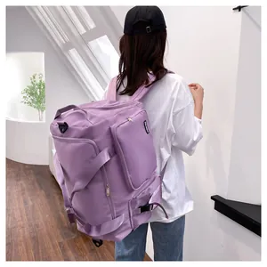 Detalle de la gran bolsa de fitness morada con bolsillos laterales y correas en modelo