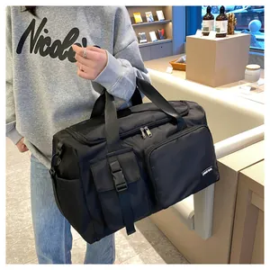 Detalle del bolso de viaje negro con bolsillo de hebilla y tejido de nailon duradero