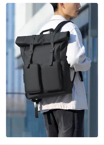 Modern black roll-top backpack with waterproof fabric shown on model in urban setting