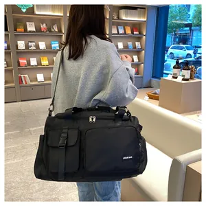 Detalle de bolsa de viaje de nailon negro con bolsillos de hebilla y ventilación