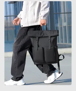 Detail of black roll-top backpack featuring waterproof fabric and dual front zippers