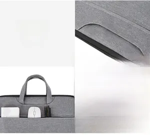 Detail of light gray oxford laptop bag showing hidden handles and zippered front pocket