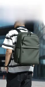 Modern dark green waterproof PU backpack shown being worn in a city street setting