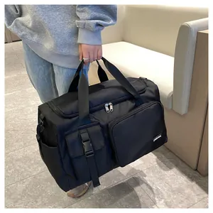 Detalle de bolsa de viaje grande negra en nylon impermeable con múltiples bolsillos y asa