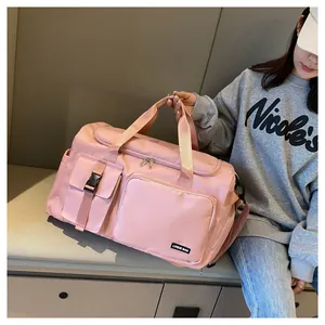 Detalle de bolsa de viaje de nailon rosa con múltiples bolsillos y cierre de hebilla