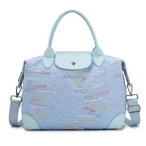 Light blue large travel tote bag with quilted M pattern and colorful wave embroidery