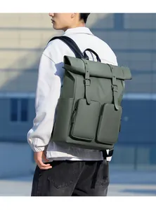 Olive green utility backpack shown on model featuring double zipper pockets and matte finish