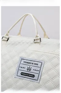 Detail of white quilted nylon gym bag featuring diamond stitching and fashion travel label