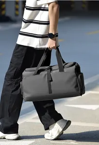 Uomo con borsa da viaggio grigia dotata di scomparto separato per vestiti bagnati